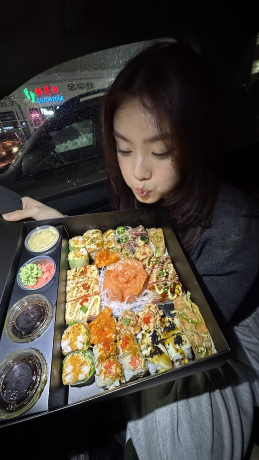 Holding a large tray of sushi in a car at night