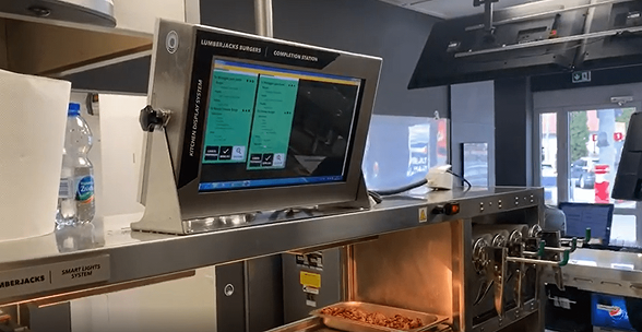 The old kitchen display system mounted in a working kitchen, showing the same fixed layout regardless of brand