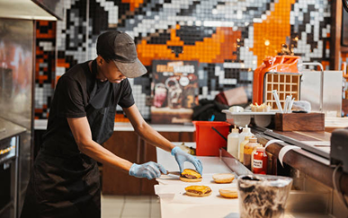 A kitchen staff member assembling an order at the prep station